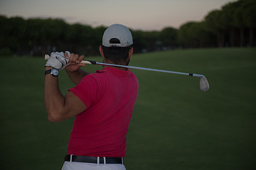 Image showing golfer hitting a sand bunker shot on sunset