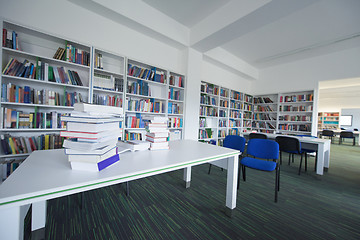 Image showing female student study in library, using tablet and searching for 