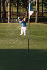 Image showing pro golfer hitting a sand bunker shot