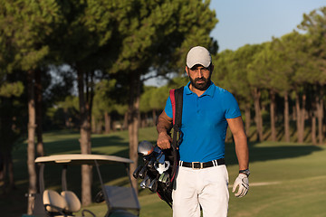 Image showing golfer  walking and carrying golf  bag