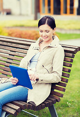 Image showing woman with tablet pc sitting on bench in park