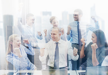 Image showing business people celebrating victory in office