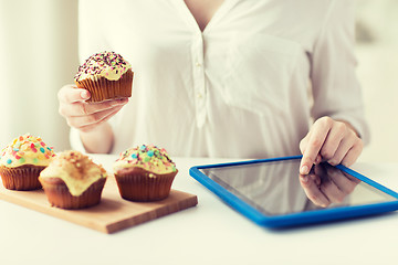 Image showing close up of woman with cupcakes and tablet pc