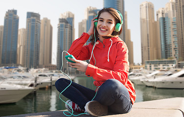 Image showing happy young woman with smartphone and headphones