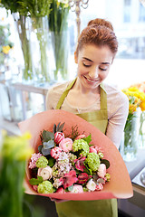 Image showing smiling florist woman with bunch at flower shop