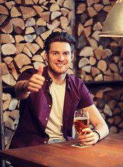 Image showing happy man with beer showing thumbs up at bar