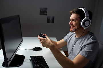 Image showing man in headset playing computer video game at home