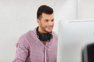 Image showing creative man with headphones and computer
