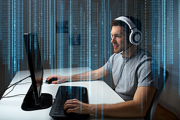 Image showing man in headset playing computer video game at home