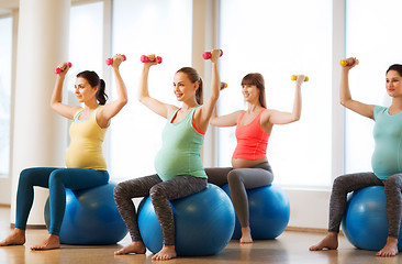 Image showing happy pregnant women exercising on fitball in gym