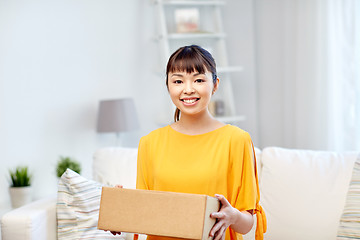 Image showing happy asian young woman with parcel box at home