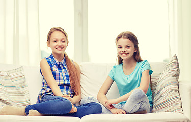 Image showing happy little girls sitting on sofa at home