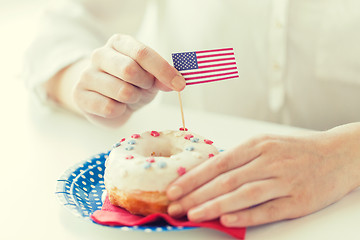 Image showing female hands decorating donut with american flag