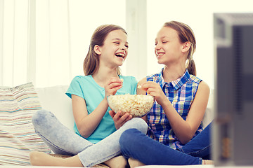 Image showing happy girls with popcorn watching tv at home