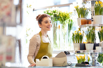 Image showing smiling florist woman at flower shop cashbox