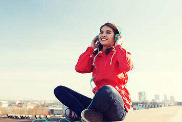 Image showing happy young woman in headphones listening to music