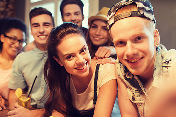 Image showing happy friends with smartphone taking selfie at bar