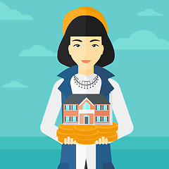 Image showing Woman holding house model.