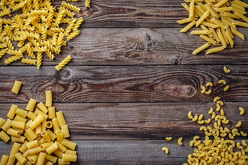 Image showing Mixed dried pasta selection on wooden background.