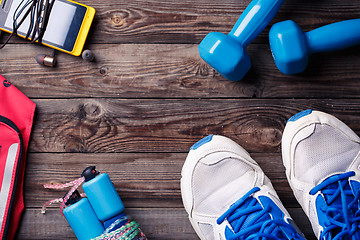 Image showing Sports equipment - sneakers, skipping rope, dumbbells, smartphone and headphones. 