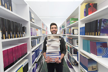 Image showing Student holding lot of books in school library