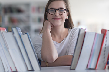 Image showing portrait of famale student selecting book to read in library