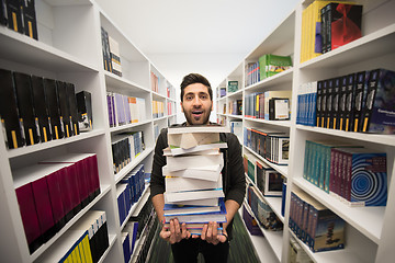 Image showing Student holding lot of books in school library