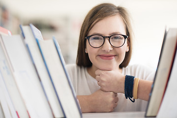 Image showing portrait of famale student selecting book to read in library