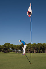 Image showing golf player hitting shot at sunny day