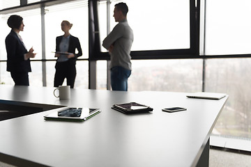 Image showing close up of tablet, business people on meeting in background