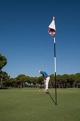 Image showing golf player hitting shot at sunny day