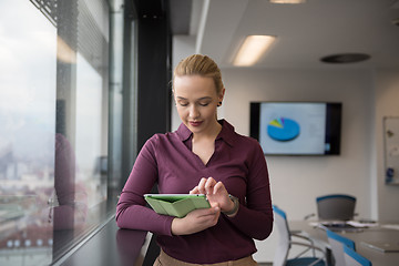 Image showing blonde businesswoman working on tablet at office