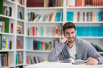 Image showing portrait of student while reading book  in school library