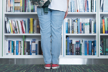 Image showing famale student selecting book to read in library