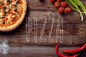 Image showing Italian pizza with tomatoes on a wooden table, top view, close-up