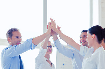 Image showing happy business team giving high five in office