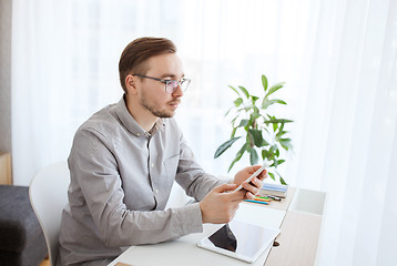 Image showing creative male office worker texting on smarphone