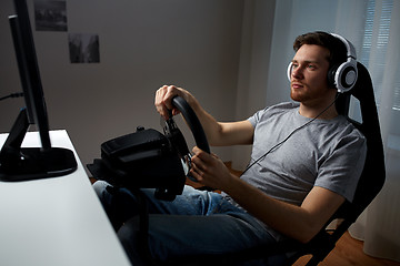 Image showing man playing car racing video game at home