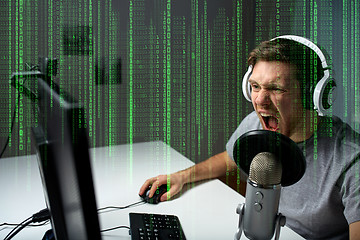 Image showing man in headset playing computer video game at home