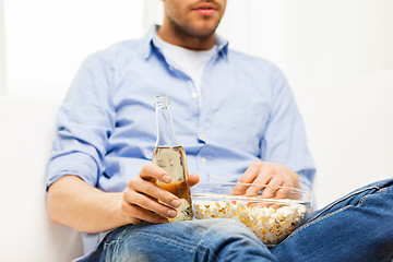 Image showing close up of man with popcorn and beer at home