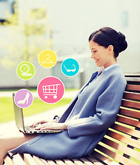 Image showing smiling business woman with laptop in city