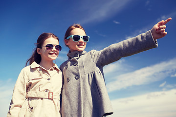 Image showing happy little girls hugging and pointing finger