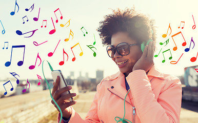 Image showing happy young woman with smartphone and headphones