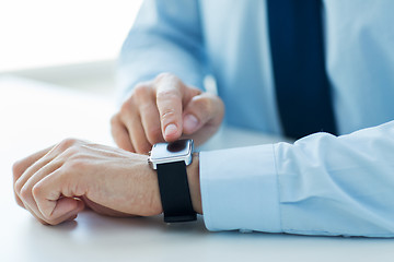 Image showing close up of male hands setting smart watch