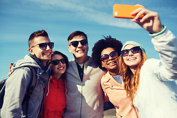 Image showing smiling friends taking selfie with smartphone