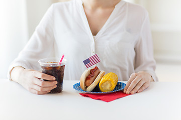 Image showing close up of woman eating hot dog with cola