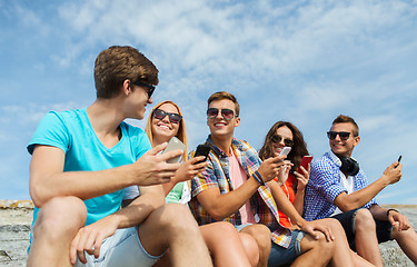 Image showing group of happy friends with smartphones outdoors