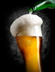 Image showing Pouring beer on black