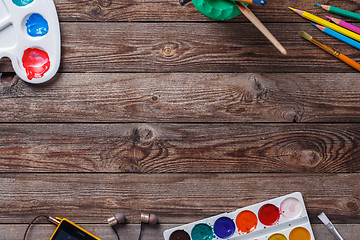 Image showing Paper, watercolors, paint brush and some art stuff on wooden   table