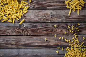 Image showing Mixed dried pasta selection on wooden background.